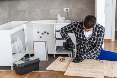 Marangoz mutfak rafının montajını bitiriyor..