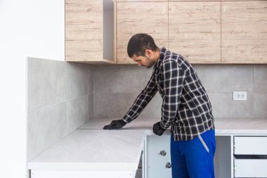 Marangoz alüminyum pervazı mutfaktaki çalışma yüzeyi yerine koyar..