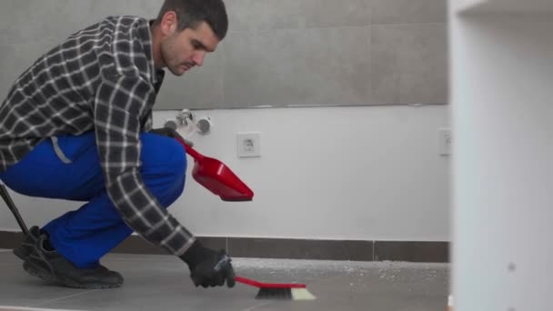 Een Timmerman Maakt Vloer Schoon Met Een Bezem Het Boren — Stockvideo