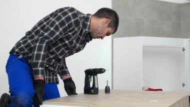 Marangoz mutfak rafının montajını bitiriyor..
