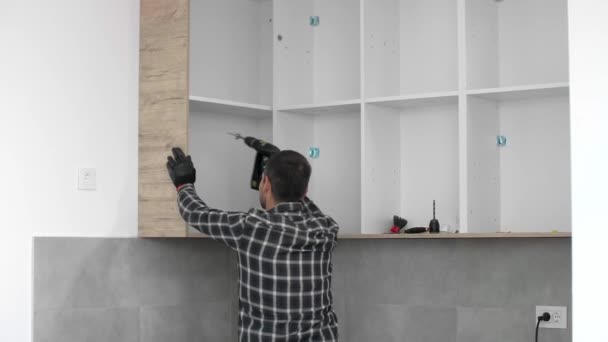 木匠在厨房的架子上螺丝钉在墙上 — 图库视频影像