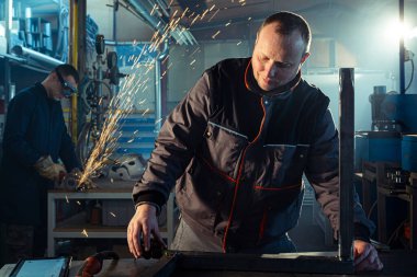 Metal çubuğu ölçen tamirci atölyede çalışıyor..