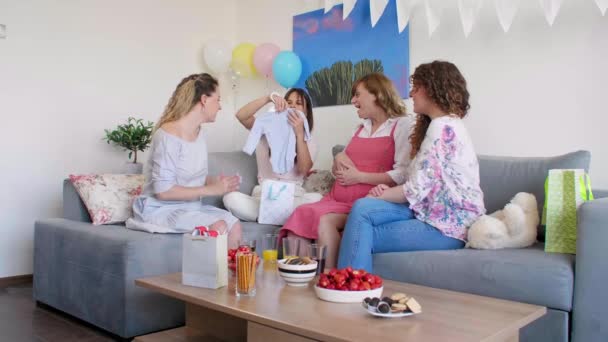 Group Smiling Friends Sitting Celebrating Baby Shower Opening Presents Atmospheric — Stock Video