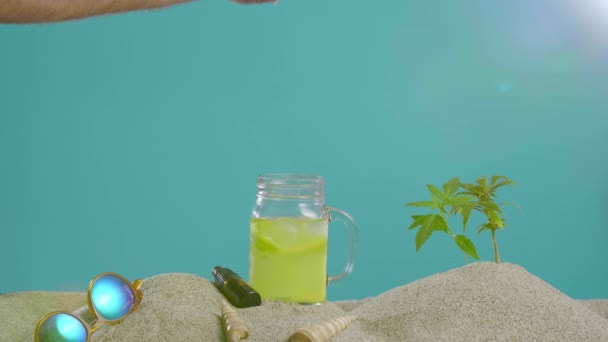 Hand Sätta Uppfriskande Cbd Lemonad Bredvid Droppolja Och Kvist Marijuana — Stockvideo