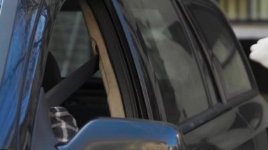 Adam, COVID-19 testi yapmaya çalışan bir tıp çalışanını reddediyor. Hastanın arabasının camından burun temizleme örneği alıyor. PPE 'de elinde test kiti olan bir doktor. Pasaportları var.