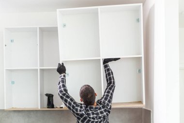 Marangoz, yeni monte edilen mutfak raflarını....