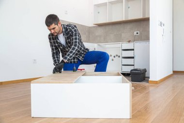 Marangoz mutfak rafının montajını bitiriyor..