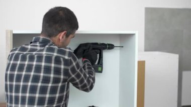 Bir marangoz mutfak rafında delik açıyor. Asılacak bir element olması amaçlanıyor..