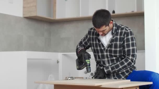 木匠在厨房架子的前面板上拧进并安装铰链 — 图库视频影像