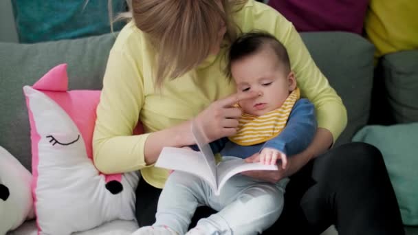 Mor Läser Bok För Sin Pojke Soffan Vardagsrummet — Stockvideo