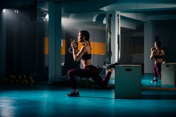 Μια Νεαρή Γυναίκα Κάνει Μια Ξεχωριστή Άσκηση Στο Άδειο Γυμναστήριο — Φωτογραφία Αρχείου