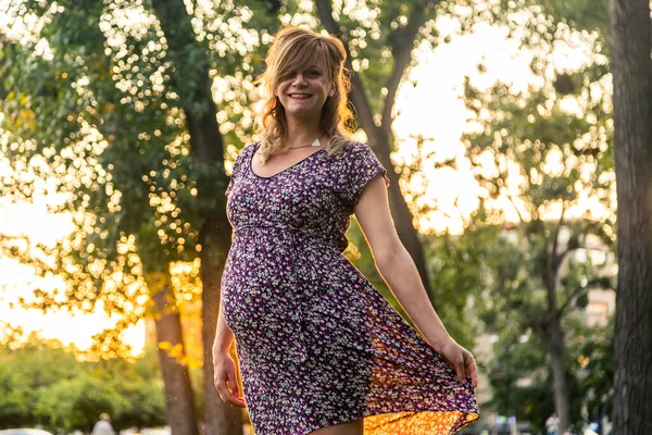 Μια Χαμογελαστή Έγκυος Γυναίκα Στέκεται Στο Πάρκο Της Πόλης — Φωτογραφία Αρχείου
