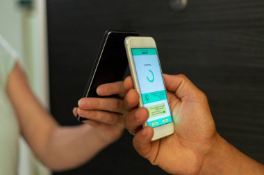 Evinin kapısındaki kadın cep telefonuyla yemek siparişini ödüyor..