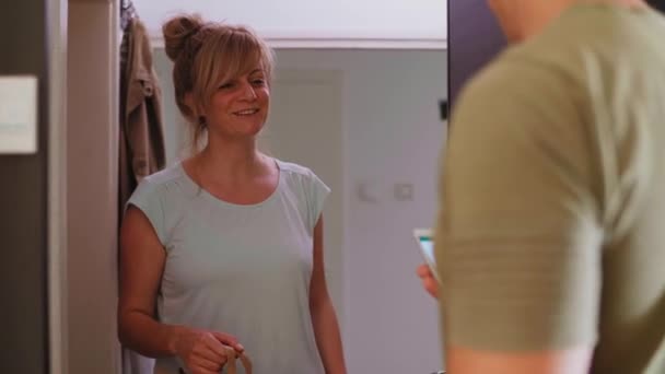 Seorang Wanita Yang Bahagia Dan Tersenyum Pintu Apartemennya Mengambil Kiriman — Stok Video