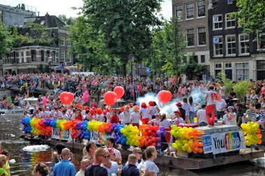 Amsterdam, Hollanda - 4 Ağustos 2012: İnsanlar eşcinsel geçit törenini kutluyor, Amsterdam kanallarında kutlama yapıyorlar. lgbt bayraklı insanlar.