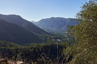 Benifairo de la Valldigna 'daki dağdaki Marinyen şatosunun müslüman tahkimatı etrafındaki dağların ve çayırların güzel manzarası, Valencia Topluluğu, İspanya