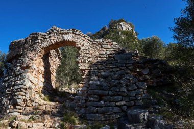 Benifairo de la Valldigna 'daki dağdaki Marinyen Kalesi' nin Müslümanların tahkimatı için alçak kapının kemerinin güzel manzarası, Valencia Topluluğu, İspanya