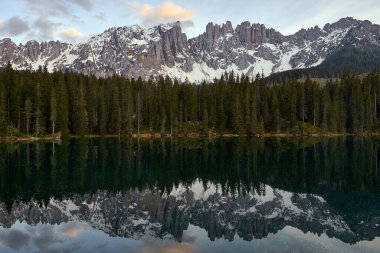 İtalyan Dolomitleri 'ndeki göldeki çam ağaçlarının ve dağların yansımasıyla lago di carezza' nın güzel manzarası.