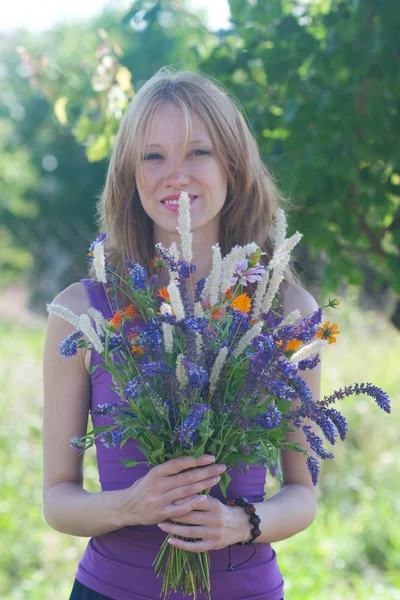 Młoda kobieta z bukietem kwiatów dzikiego — Zdjęcie stockowe