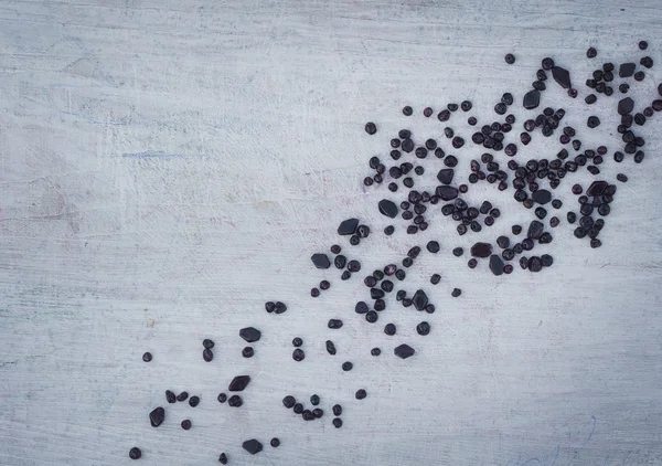 Dispersos en el tablero blanco de madera perlas oscuras — Foto de Stock