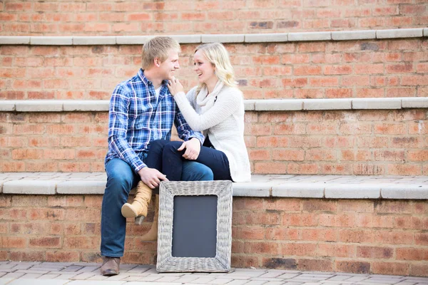 Attractive young caucasian couple smiling at each other — Stock Photo, Image