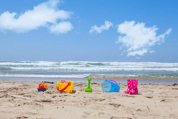 Colorido brinquedos de praia de plástico deitado na areia da praia — Fotografia de Stock