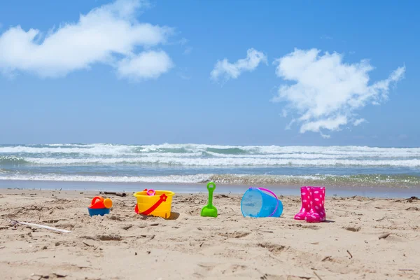 Kleurrijke kunststof strand speelgoed liggend op het strand zand — Stockfoto