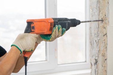 Yıkıcı çekiçli işçiler duvardan alçı ya da sıva çıkarıyorlar.