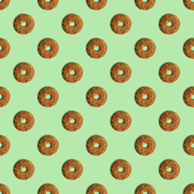 Yeşil arka planda susam tohumlu kurabiye şablonu. Yukarıdan bak. Yaratıcı tasarım, minimal düz konsept.