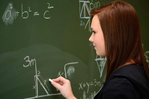 Student in calculations on a school blackboard — Stock Photo, Image