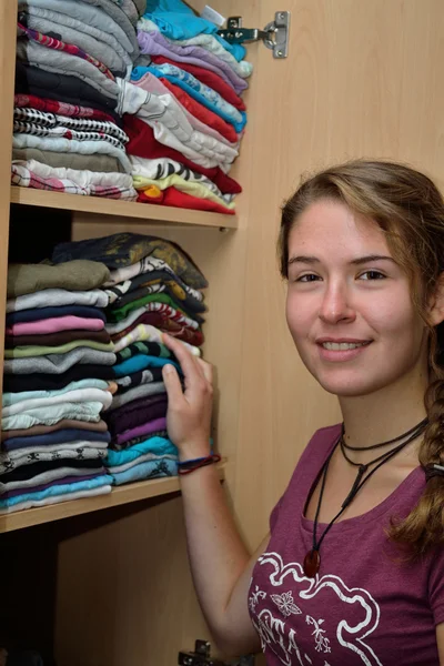 Oung woman in front of a closet — Stock Photo, Image