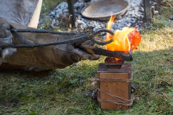 Schmied gießt Bronze in Form eines Sandkastens — Stockfoto