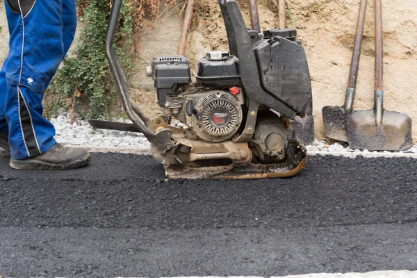 Travailleur de la construction avec plaque vibrante — Photo