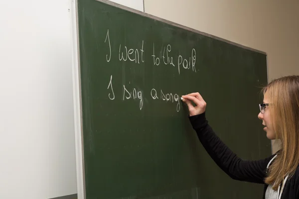 Studentin schreibt an die Tafel — Stockfoto