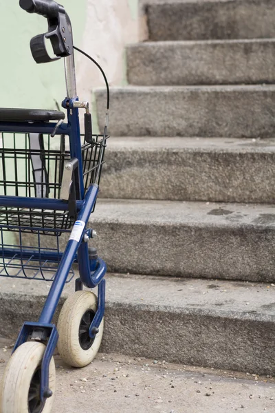 Walker parked in front of a staircase — Stock Photo, Image