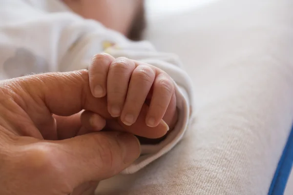 Babyhand und Erwachsenenhand - Nahaufnahme — Stockfoto