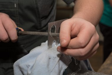 Person polishes metal piece - Closeup clipart