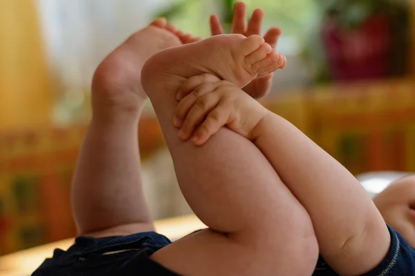 Baby bereiken voor hun eigen voeten — Stockfoto