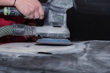 Sanatçı metali öğütücüyle öğütüyor. Yakın plan.