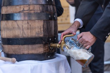 İlk bira bardağını tıkırdatırken ve doldururken tahta bira fıçısı - yakın çekim