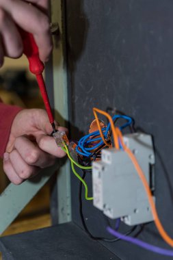Kalifiye işçi soket takar ve yetenekli işçi aletleriyle röle yapar - kapat