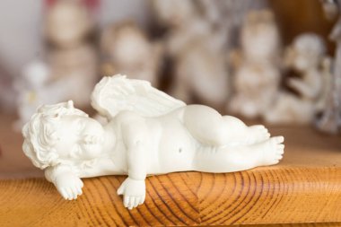 Beyaz melek figürü rahatlamış yatıyor - bokeh etkisi, yakın plan