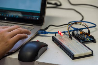 Yetenekli işçiler dizüstü bilgisayarda elektrik mühendisliği parçaları ile çalışıyorlar. Elektrik mühendisi, yakın plan.