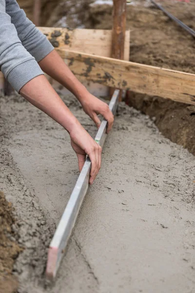 コンクリートを注ぐときに測定棒を持つ建設労働者 クローズアップ建設 — ストック写真