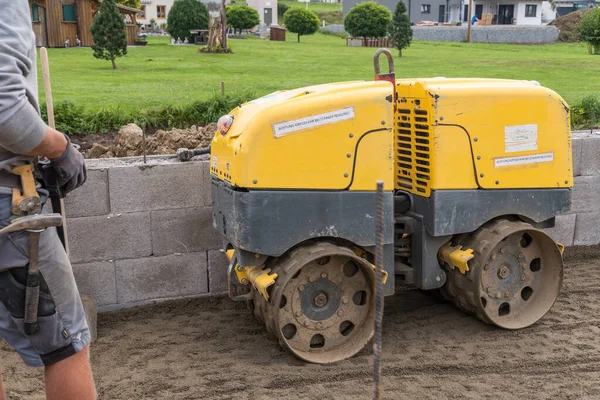 構造物をコンパクトにするためにトレンチローラーで建設現場で作業する — ストック写真