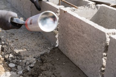 Zanaatkar inşaat sahasında köpükle çalışıyor.