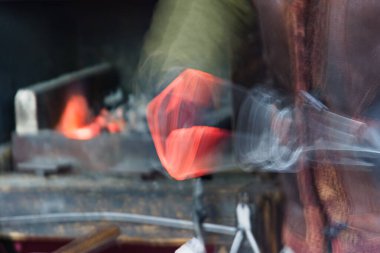 Arkaplan olarak bulanık bir tasarım içinde parlayan metalle dövmek