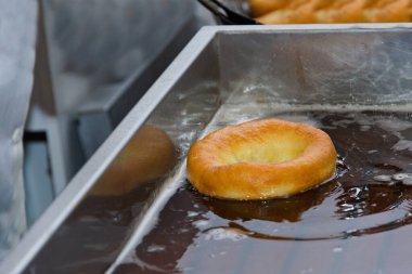 Bir çiftçinin donutu sıcak yağ içinde yüzerken kızarır..