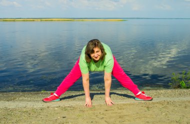 Woman exercise on the river bank