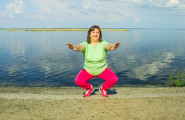 Woman exercise on the river bank